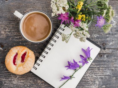Bir fincan sıcak, aromatik kahve ve güzel çiçekler. Yakından, yukarıdan, içeriden.