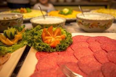 Bir çanak içinde dilimlenmiş sosis güzel sebzeler ile dekore edilmiştir.