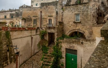 Matera, İtalya - 28 Aralık 2019 - İtalya 'nın güneyindeki Basilicata bölgesinde güzel bir taş şehrin tarihi merkezi. Eski şehrin eski caddesinin manzarası.