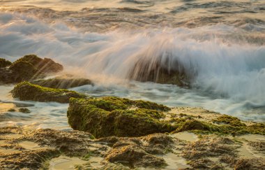 Bir yaz akşamı gün batımında kayalara çarpan dalgaların görüntüsü, İsrail, Ashkelon