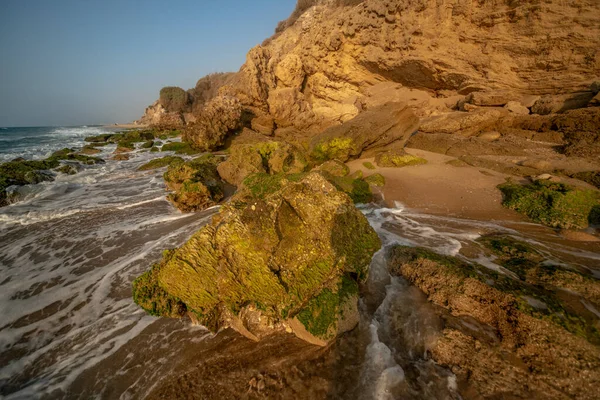 以色列 阿什凯隆 夏夜黄昏时海浪拍击岩石的景象 — 图库照片