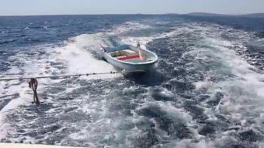 Yolda küçük bir tekne ile masmavi denizin karşısında