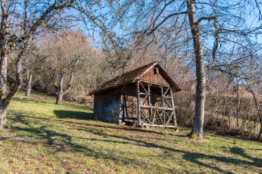 Çimen ve ağaçlarla bahçenin ortasında küçük hovel