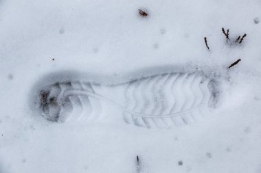 Beyaz kar üzerinde bir insan ayakkabısı ayak izi