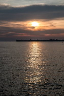 Suya küçük bir kara tükürüğü ve altın bir günbatımı