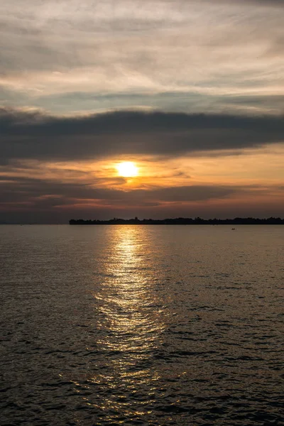 Kleine schwarze Landzunge ins Wasser und ein goldener Sonnenuntergang — Stockfoto