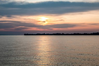 Suya küçük bir kara tükürüğü ve altın bir günbatımı