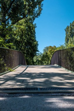 Nehrin üzerindeki beton köprü ve yeşil ağaçlar.