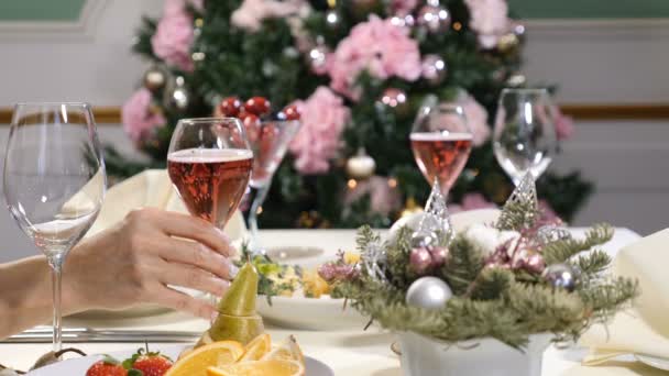Conceito de restaurante. Ano Novo e mesa de festa de Feliz Natal. mãos femininas leva, segura e, em seguida, coloca uma taça de champanhe com bolhas . — Vídeo de Stock