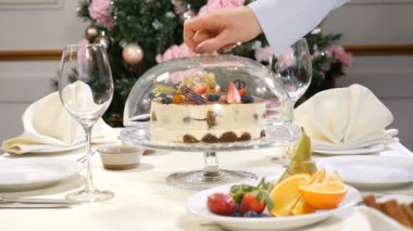 Restaurant konseptini. Yeni yıl ve neşeli Noel Bayramı tablo. Garson eldiven açılıp kapanıyorsa meyveli pasta ile cam yemek