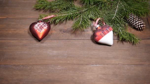 Nyår och jul vykort. Snö faller på julgran dekoration placerade på trä bakgrund. Ovanifrån — Stockvideo