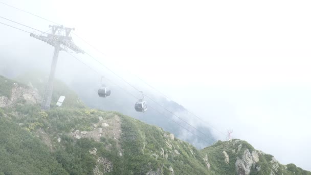 Sochi, Roza Khutor w okresie letnim. Kolejka linowa lub kolejką w górach. Mgła. Mgła — Wideo stockowe