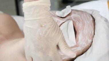 Sağlık kliniği. Genç çekici kadın profesyonel yüz bakımı alıyorum. Şevval özçelik Güzellik yüz krem maske yüz bir parmak ile yayılır. Gözler Pamuklu ped ile kapalı