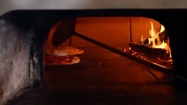 Pizza wird im traditionellen Holzofen Pizza-Brot Restaurant gebacken. Pizzabäcker Koch Kochen Pizza im Restaurant offene Küche. Pizza wird im traditionellen Holzofen Pizza-Brot Restaurant gebacken. Pizzabäcker Koch Kochen Pizza im Restaurant offene Küche.