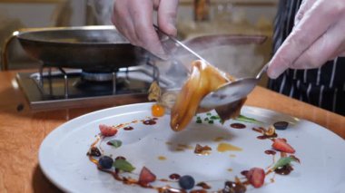 Garson. Şef garson Flambe stil krep meyveler ve meyve ile süslenmiş bir tabakta Close-up. Restaurant konseptini. Ağır çekim
