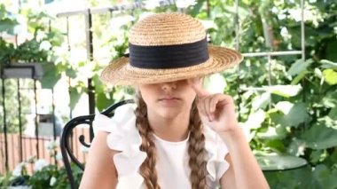 Hasır şapka ile oynayan genç çekici gülümseyen kız portresi. Yaşam tarzı kavramı. Mutlu çocukluk.