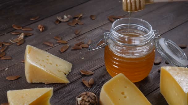 Honung och ost. Restaurang bordet servering. Hårdost med nötter på trä bakgrund — Stockvideo