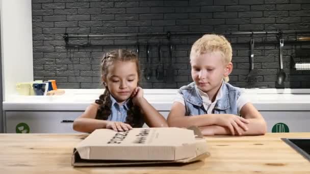 Τα παιδιά τρώνε. Δύο αρκετά παιδιά άνοιγμα pizzabox και βλέποντας την πίτσα σε απόλαυση. Αγαπημένο φαγητό για τα παιδιά. 4k — Αρχείο Βίντεο