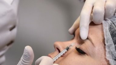 Güzellik klinikte. Genç çekici kadın güzellik kaydetmek için yüz enjeksiyon alır. Şevval özçelik güzellik elinde bir şırınga ile eyebrowns.4k arasında göz çevresi içine enjeksiyon yapar