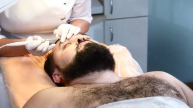 Acımasız darkhaired adam tıbbi köstebek ve tıp merkezinde yordam kaldırma Papillomas alır. Doktor erkek göz kapağı kapalı papillom kaldırır. 4k