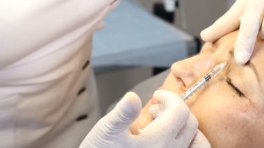 Atış uzman Şevval özçelik güzellik el şırınga Botox ile kapatın. Kadın hastada güzellik salonu. Enjeksiyon kozmetik. 4k