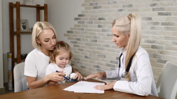 健康診査。若い母親と彼女の小さなかわいい娘は、小児科医をご覧ください。フレンドリーな子診療所。ママと 4 k を話して doc — ストック動画