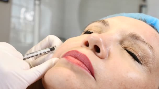 Botox. collageen injecties. Arts maakt meerdere injecties. Gezicht opheffing van de procedure. Senior vrouw in schoonheid kliniek. 4k — Stockvideo