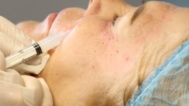 Üst düzey kadın kozmetik kliniğinde. Kadın müvekkilinin yüz enjeksiyon almak yakın. HD