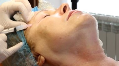 Üst düzey kadın kozmetik kliniğinde. Kadın müvekkilinin yüz enjeksiyon almak yakın. HD