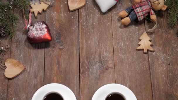 Buon Natale e felice anno nuovo concetto. Tazze di caffè poste su fondo di legno insieme a rami di abete e giocattoli a forma di cuore. Buon Natale nota è messo vicino tazze — Video Stock