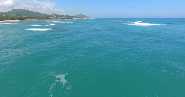 Voando sobre belas ondas do mar turquesa. Oceano incrível sob drone voador com uma ilha no horison. 4k — Vídeo de Stock