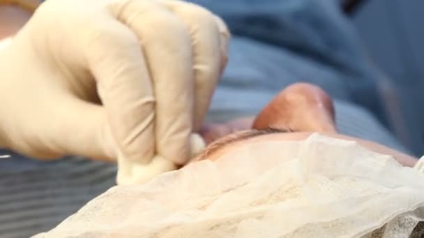 Clinique de cosmétologie moderne. Seringue dans des mains d'esthéticienne. Une jeune femme qui se fait injecter du visage. 4k — Video