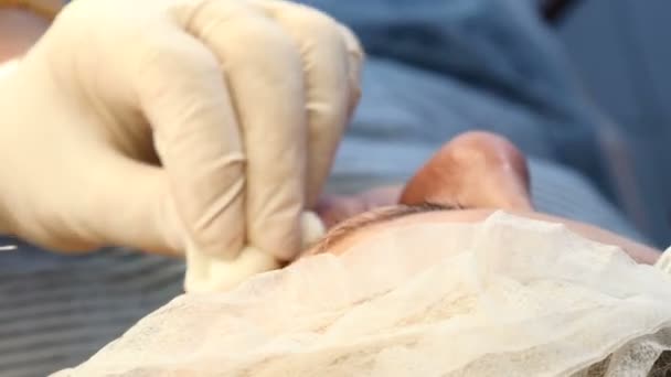 Clínica cosmetológica moderna. Jeringa en manos de esteticista. Mujer joven recibiendo inyecciones faciales. 4k — Vídeo de stock