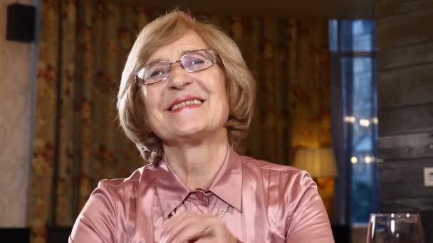 Látszó-on fényképezőgép nyugdíjas asszony portréja. Boldog szenilitás. Idősebb nő, akit a szemüveg, mosolyogva és nevetve. 4 k — Stock videók