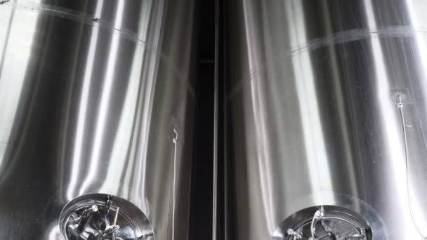 在啤酒厂生产啤酒钢储罐和管道。啤酒生产线设备分阶段生产成品金属吹笛机的装瓶。现代化的啤酒厂。4k — 图库视频影像