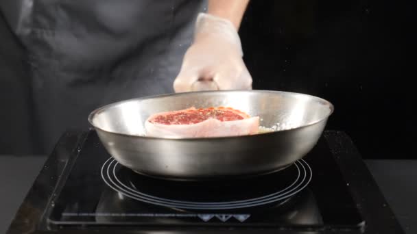 Concetto di cucina. Bistecca fritta in olio al rallentatore. Chef professionista che cucina carne. hd — Video Stock