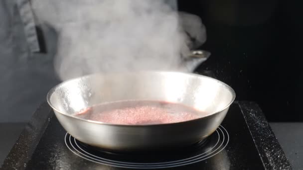 Професійний шеф-кухар в ресторані, що розливає цукор на сковороду, готує смачний соус. 4k — стокове відео