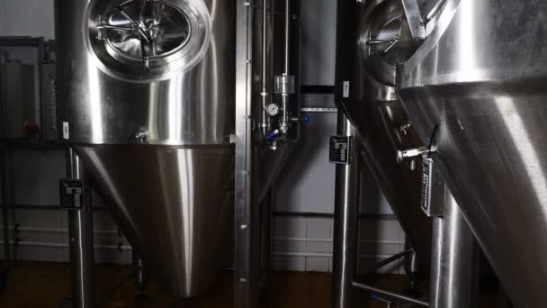 Producción de depósitos y tuberías de acero para cerveza en una cervecería. Equipo de línea de fabricación de cerveza para el embotellado por etapas de producción de productos alimenticios terminados gaitero de metal. Cervecería moderna. 4k — Vídeo de stock