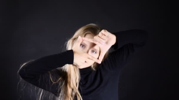 Retrato de niña rubia modelo aislado en negro. Lindo modelo adolescente de pelo blanco en negro que muestra símbolos con las manos, posando. 4k — Vídeos de Stock