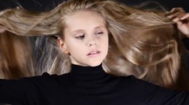 Portre Studio siyah arka plan üzerine küçük modeli. Kameraya bakarak, poz saçlarını dokunmadan.