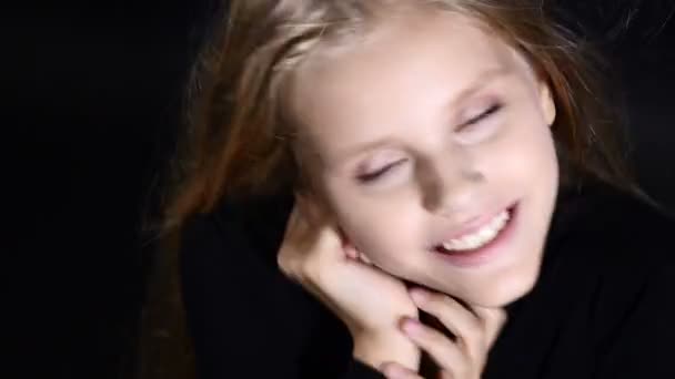 Sevimli küçük model siyah izole Studio poz. Beyaz - saçlı kız kameraya, gülümseyen, 4 k görünüyor — Stok video