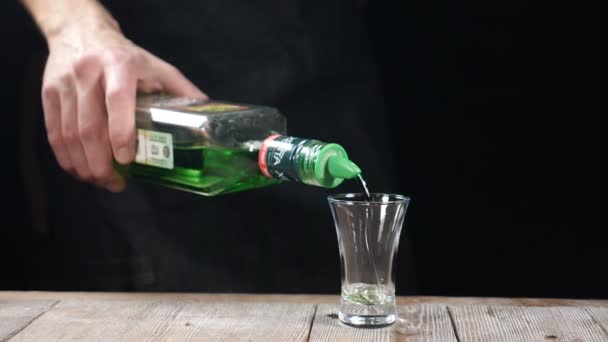 바텐더 손 따르는 강한 알콜 음료 슬로우 모션에서 병에서 총에. 알콜 칵테일 주사를 준비 하는 바텐더. hd — 비디오