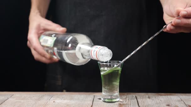 Barman ręka odlewania silne napój alkoholowy na strzał z łyżką butelki w zwolnionym tempie. Barman przygotowuje alkoholowe cocktail strzał. HD — Wideo stockowe