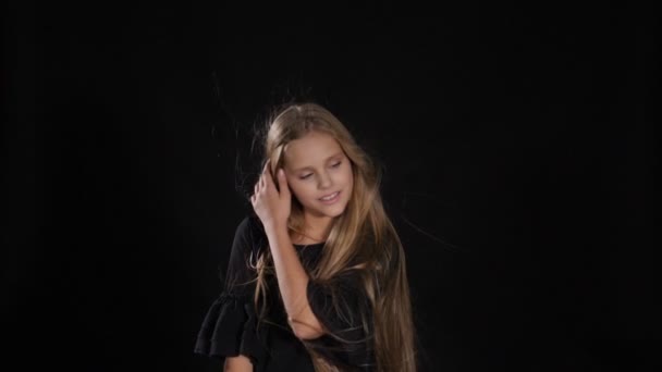 Mooi klein model poseren in studio geïsoleerd op zwart. Wit - haired meisje kijkt naar camera, glimlachen, hd — Stockvideo