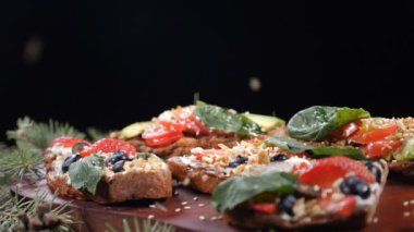 Fındık kürk ağaç dalları ile birlikte siyah arka plan üzerine koymak sandviç çeşitli çanak üzerinde düşme. Ağır çekim. HD