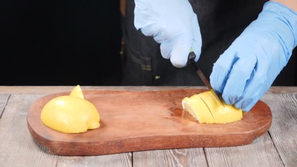 Professionell kock skivning citron med kniv på skärbräda i slow motion. HD — Stockvideo