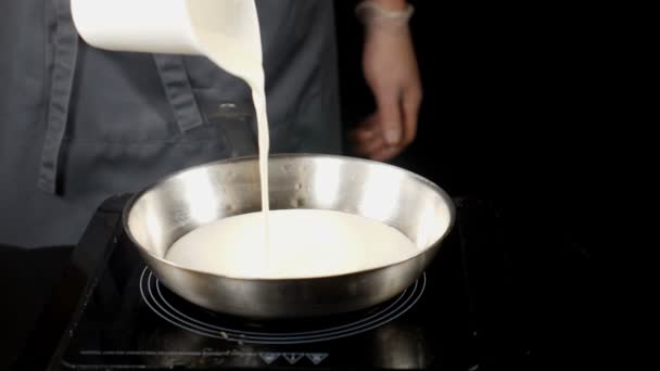 Concept des professionnels au travail. concept gastronomique. Faire cuire dans des gants en versant la crème dans la poêle à frire la sauce à la crème au ralenti. hd — Video