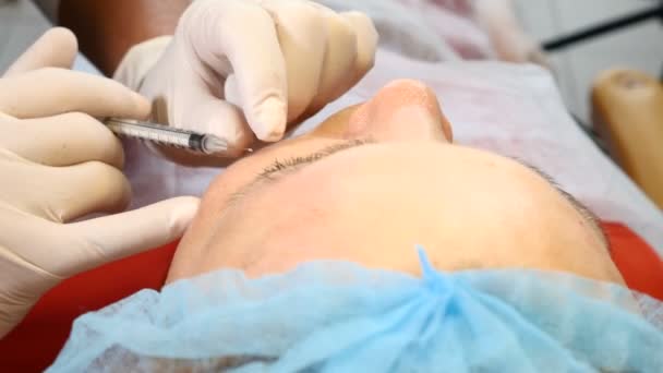 Una inyección de belleza. Mujer en una clínica de salud. El esteticista hace la inyección facial. Levantamiento facial. Vista superior. De cerca. 4k — Vídeos de Stock