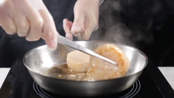 Het koken van schaal-en schelpdieren. gezonde voeding-concept. Professionele chef-kok in handschoenen koken van Sint-jakobsschelpen draaien ze met een culnary Tang in slow motion. HD — Stockvideo