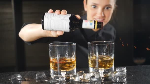 Concept de fabrication de cocktails. Le barman prépare un cocktail avec de l'alcool au comptoir du bar, en ajoutant quelques gouttes au ralenti. Barman femme en uniforme noir souriant tout en préparant une boisson. hd — Video